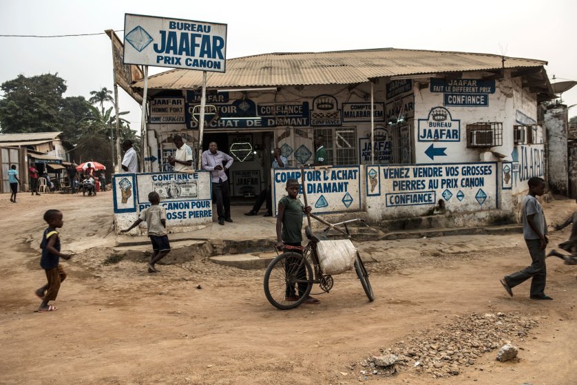 Congolese walk past Jaffar Comptoir, a diamond trading house, in Tshikapa, in Kasai, in the south west region of the Democratic Republic of Congo, August 10, 2015. Diamond buyers and manufacturers in the west are trying to find a way to make the diamond industry cleaner and more responsibly-sourced, in order to combat human rights abuses, child labor, the degradation of the environment, and unfair trade practices. (Credit: Lynsey Addario/ Getty Images Reportage for Time Magazine)